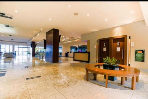 a lobby with a table in the middle of a building at Beira Mar - Flat Beach Class Internacional - Boa Viagem 20º andar in Recife
