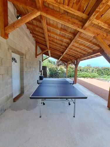 a ping pong table in a pavilion with a wooden ceiling at le chemin des Bérands chambres d'hôtes Renaison in Renaison
