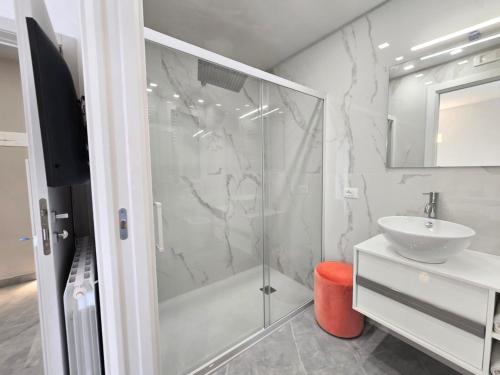 a white bathroom with a shower and a sink at Just Light in San Leone