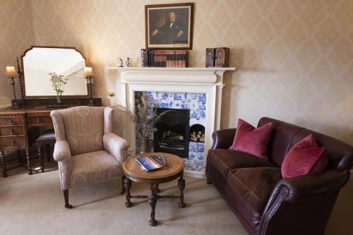 a living room with a couch and chairs and a fireplace at Knockinaam Lodge in Portpatrick