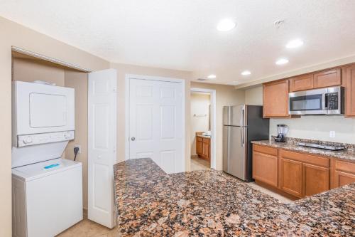 a kitchen with a white refrigerator and a counter top at Vacation Village at Parkway in Orlando