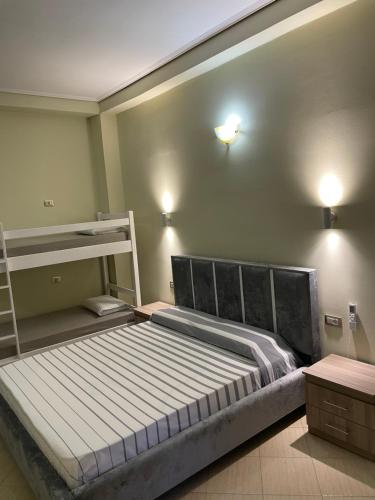 a bedroom with a bed and bunk beds in it at Harmonia Guest House in Vlorë