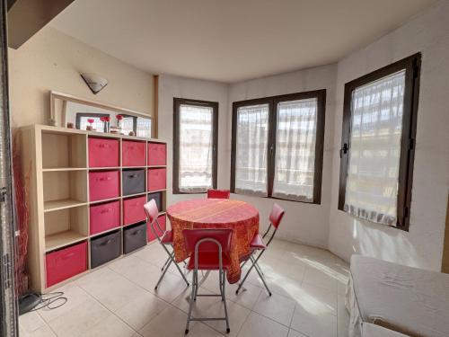 une salle à manger avec une table et des armoires roses dans l'établissement Centre Juan les Pins studio avec loggia Standing Rives Bleues, à Antibes