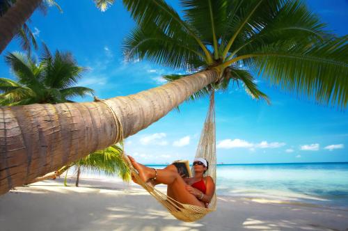 a woman sitting in a hammock on a beach at Maqai Beach Eco Resort in Qamea