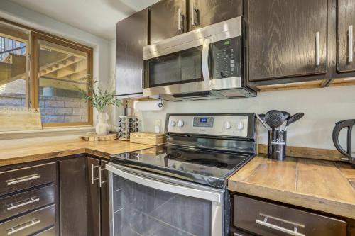 a kitchen with stainless steel appliances and wooden cabinets at Aspen Haven - Mountain Retreat BBQ Scenic Views in Divide