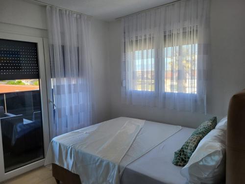 une chambre avec un lit et une fenêtre avec des rideaux dans l'établissement Apartmani VIR, à Vir