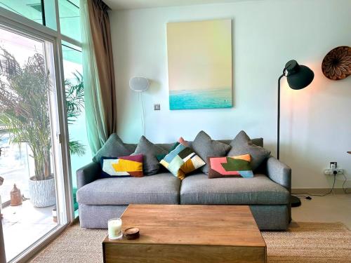 a living room with a couch with colorful pillows at 2BR with Breathtaking Sea View Yas Proximity in Abu Dhabi