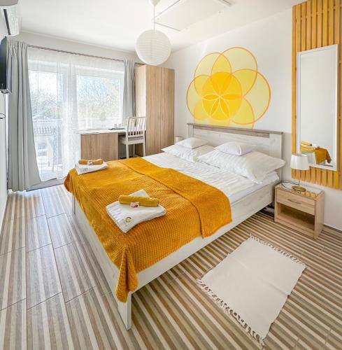 a bedroom with a large bed with an orange blanket at Zen House ADULT ONLY 16plus in Hajdúszoboszló