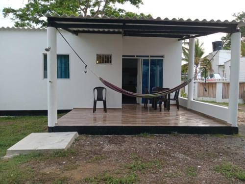 a porch with a hammock and a house at Cabaña Los Cristales Coveñas by Amauna in Coveñas