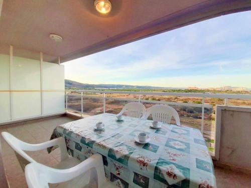 Un comedor con mesa y sillas y una gran ventana. en Ayf colomeras espacioso playa morro de gos, en Oropesa del Mar