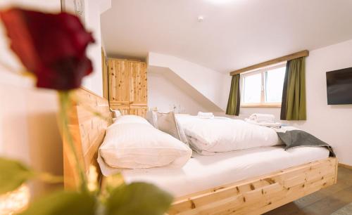 a bedroom with a wooden bed with a window at Landgasthof Rechenwirt in Elsbethen