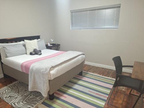 Un dormitorio con una cama con un osito de peluche encima. en Eazy Rest, en Gqeberha