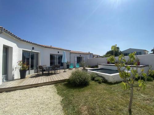 une arrière-cour d'une maison avec une terrasse en bois dans l'établissement La Villa de la Clavette, à La Flotte