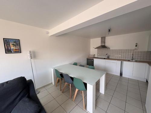 a kitchen with a table and chairs in a room at Appartement cosy avec terrasse au calme in Urcuit