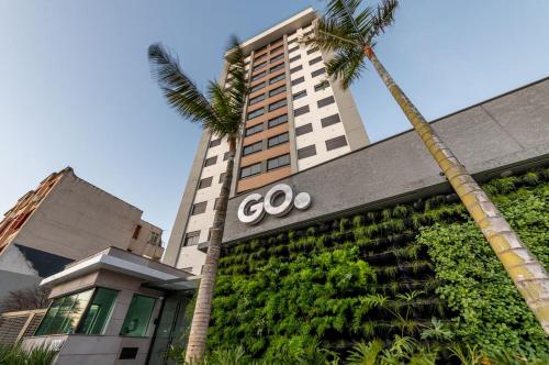ein Cole-Schild an der Vorderseite eines Gebäudes mit einer Palme in der Unterkunft POA Heart Stay - Vista para o Guaíba no Centro Médico de Porto Alegre in Porto Alegre