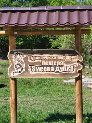 a wooden sign in a park with a roof at Alba in Tryavna