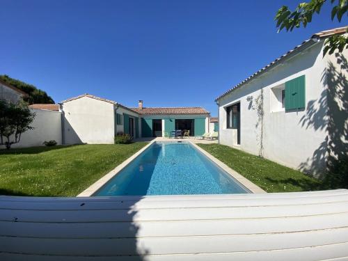 une piscine dans une cour à côté d'une maison dans l'établissement La Villa du Platin, à La Flotte