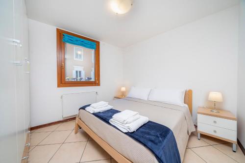 a bedroom with a bed with two towels on it at Porto Vecchio Home in Grado