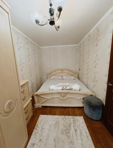 a small bedroom with a bed and a chandelier at Fly Apart in Turksib
