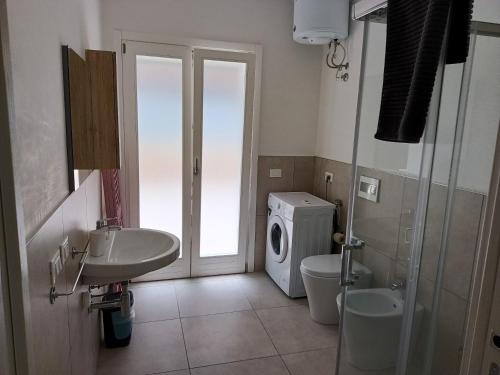 a bathroom with a sink and a washing machine at sosta modicana in Modica
