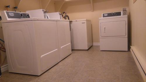 a laundry room with two washers and a dryer at Oasis Motel in Antigonish