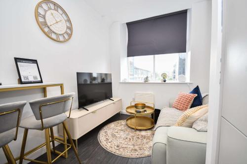 a living room with a couch and a clock on the wall at Modern & Compact 1 Bedroom Apartment in Bradford in Bradford