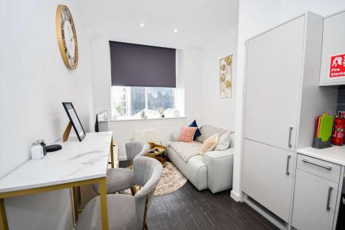 a white living room with a couch and a table at Modern & Compact 1 Bedroom Apartment in Bradford in Bradford