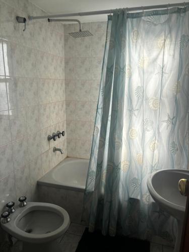 Un baño con bañera, inodoro y lavabo. en Apartamento Pacifico Delta Suites, en Bahía Blanca
