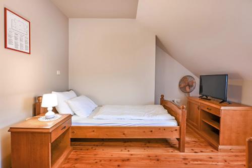 a small bedroom with a bed and a tv at Turistična Kmetija Pungračič in Zavrč