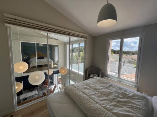 een slaapkamer met een bed en een groot raam bij La Villa l Olivier in La Flotte