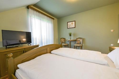 a bedroom with a bed and a flat screen tv at Turistična Kmetija Pungračič in Zavrč