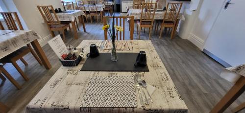 a wooden table with a vase of flowers on it at The Aldor in Skegness