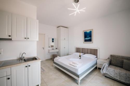 a white bedroom with a bed and a couch at Mariana Apartments in Sarandë