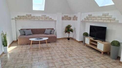 a living room with a couch and a tv at Апартамент ReLax Китен in Kiten