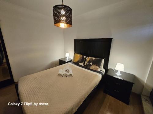 a bedroom with a bed with two shoes on it at Ap Central Chic in Odivelas
