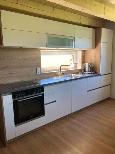 a kitchen with white cabinets and a sink at Ferienwohnung Mondsee-Irrsee in Tiefgraben