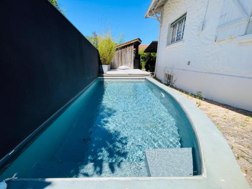 a swimming pool in the backyard of a house at Soimi, villa 4 chambres, petite piscine, plages a pieds in Pyla-sur-Mer