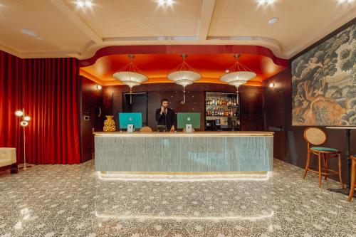 a man standing at a bar in a hotel lobby at ABC Hotel Porto - Campanhã in Porto