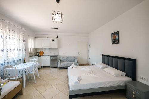 a bedroom with a bed and a kitchen at Mariana Apartments in Sarandë