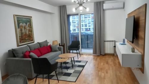 スコピエにあるArt Galerija Apartment Skopjeのソファとテーブルのあるリビングルーム