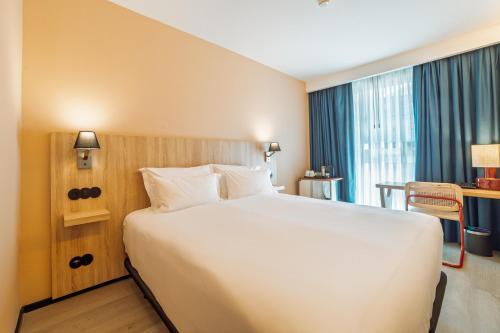 a hotel room with a large white bed and a window at ABC Hotel Porto - Campanhã in Porto