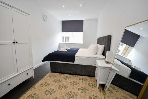 a bedroom with a bed and a desk and a mirror at Compact & Convenient 1 Bed Apartment in Bradford in Bradford