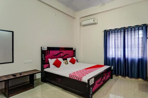 a bedroom with a bed and a tv in it at Hotel O Gangotri Inn in Gulzārbāgh