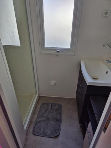 une salle de bain avec une douche et un lavabo et une fenêtre dans l'établissement Finouche, à Vias