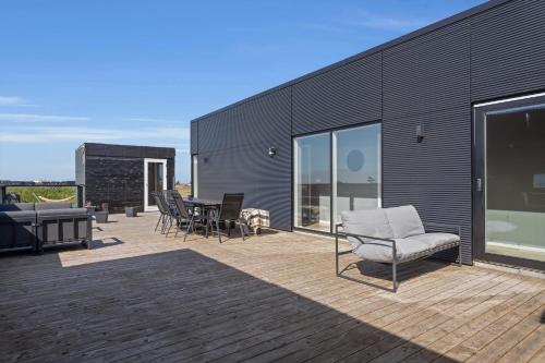 a deck with chairs and a table on a building at Mói Byggðarhorn in Selfoss