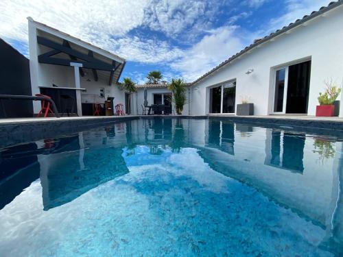 a swimming pool in front of a house at La Villa des Vignes in Les Caillaux