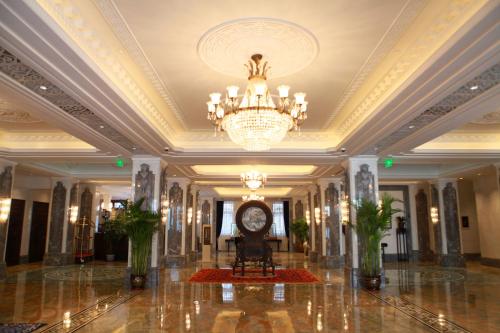a large lobby with a chandelier and a clock at Shanghai Donghu Hotel - Shanghai Style Garden House in Shanghai
