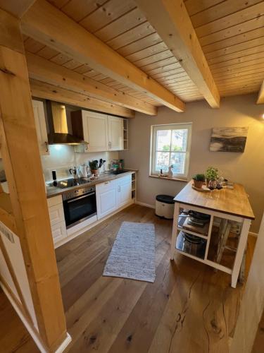 a large kitchen with white cabinets and a wooden floor at Ferienhaus Fachwerk Sanct Peter in Bad Neuenahr-Ahrweiler