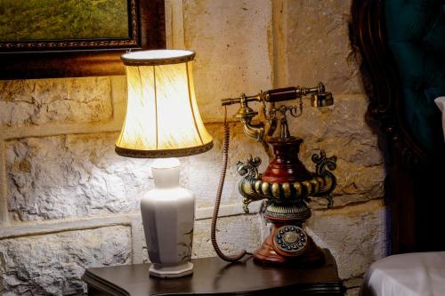a lamp on a table with a vase and a clock at Chateau Du Comte 