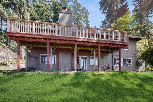 a house with a large deck on top of it at Snug Harbor Hideout in Islandale